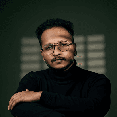 Sreenu RJ in a black turtleneck, arms crossed